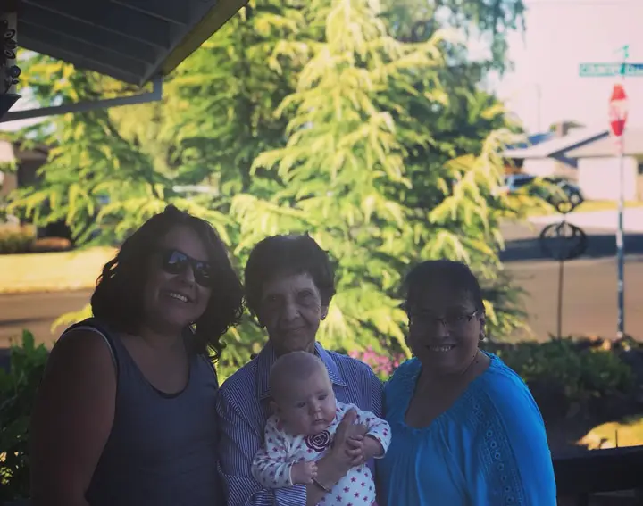 Four generations of the family together, with a baby held at the center